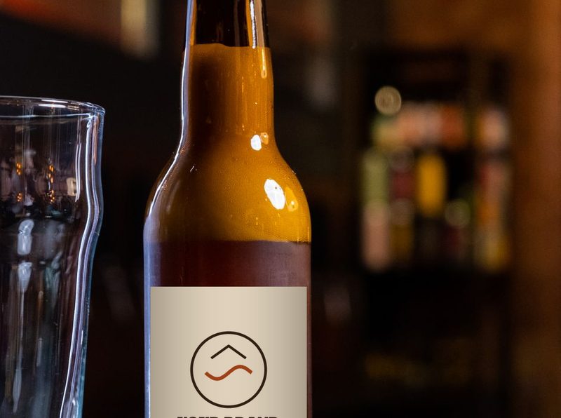 Amber bottle with a cream label and a sample logo